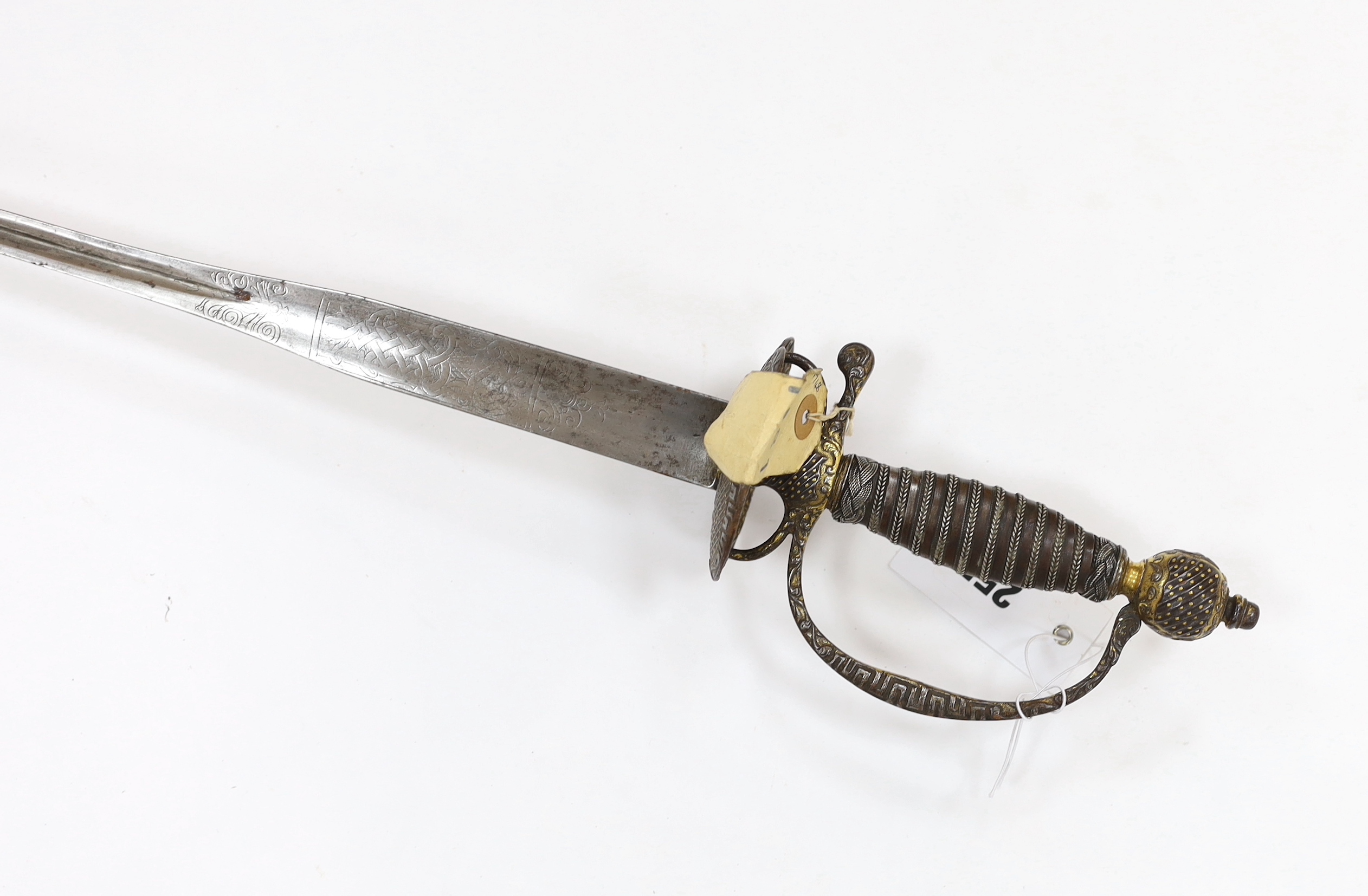 A French iron hilted small sword, hilt with flutes and tiny gold dots, the knuckle guard with key decoration, iron tape and silver wire bound grip, colichemarde blade with etched strapwork decoration, c.1770, blade 83cm